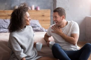 Talk to me. Smiling happy lovely couple having a warm conversation while drinking coffee and spending morning together.